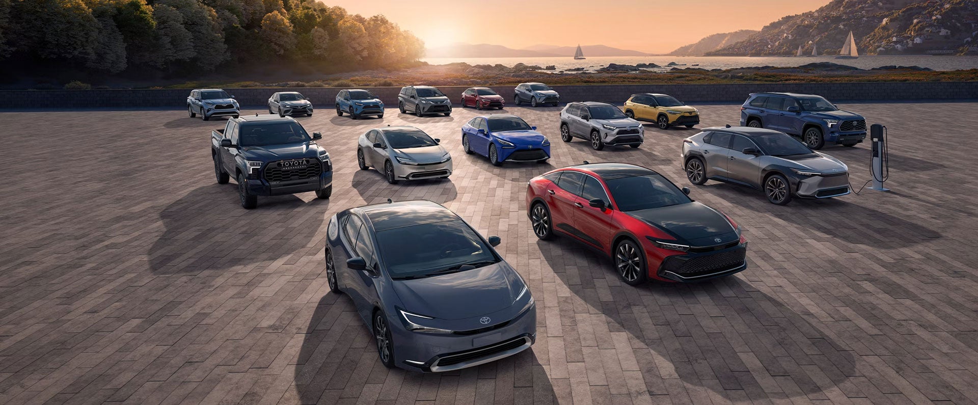 Lineup of Toyota cars, SUVs and trucks parked together at sunset